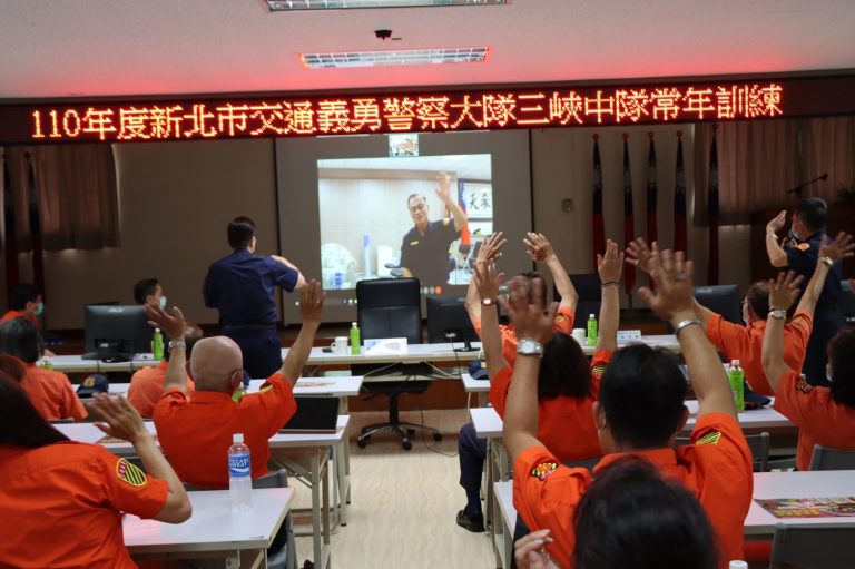 圖片說明:阿仁局長非常重視民力,因需前往議會,但又心繫三峽中隊義交人員訓練情形,首創用視訊連線與現場的義交人員互動。(記者宋紹誠翻攝)