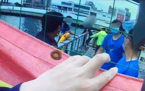 圖片說明：民眾「即刻救援」，使用救生圈將在海中載浮載沉的男子救上岸。(記者宋紹誠翻攝)