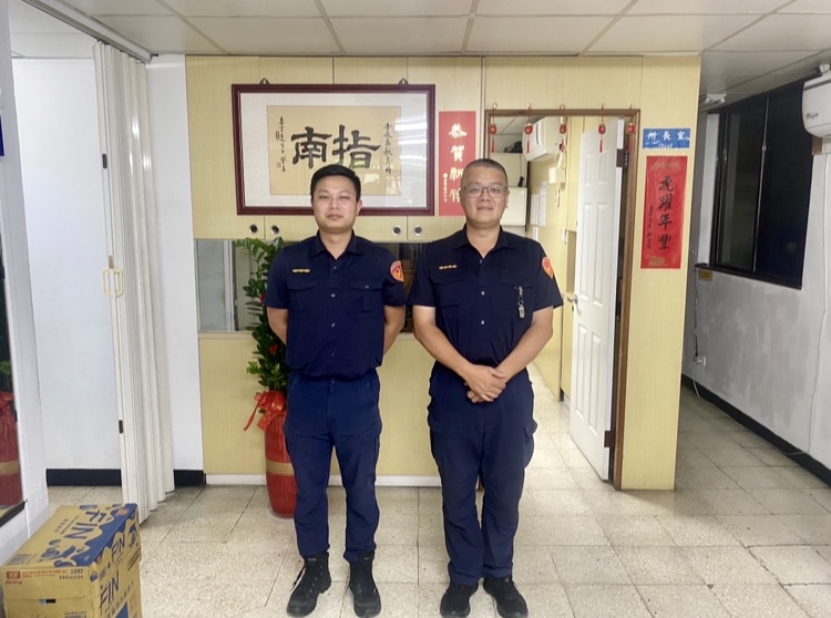 圖片說明：指南所員警羅元榮、蔡渲棋徒手推車助「顧路」民眾從車陣中脫困。（記者趙靜姸翻攝）
