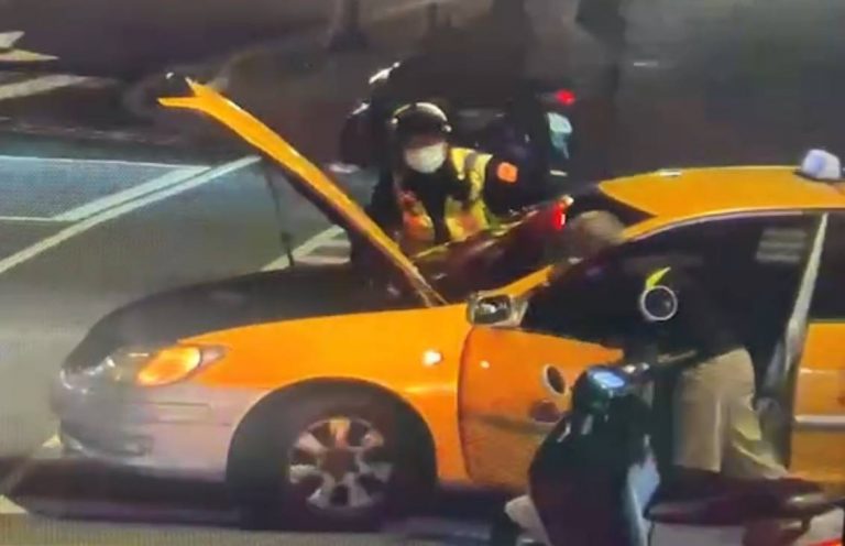 警員協助運匠將拋錨小黃推至路邊。（記者林金聖翻攝）