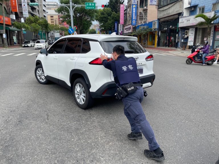 巡邏警員協助陳姓車主將熄火的新車推至路邊。(記者張欽翻攝)