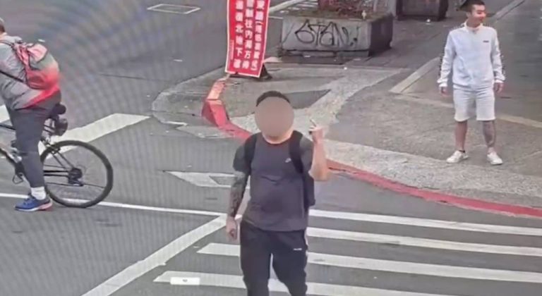 男子闖紅燈過斑馬線對停等車輛比中指挑釁。（記者林金聖翻攝）