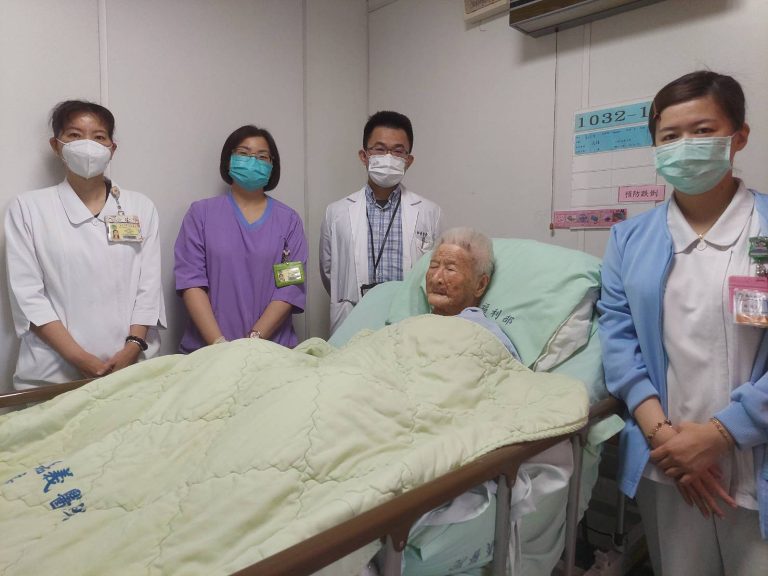 部嘉醫院張書豪醫師腹腔鏡手術成功救治近百歲人瑞並與醫療團對照護時合影。（部嘉醫院提供）