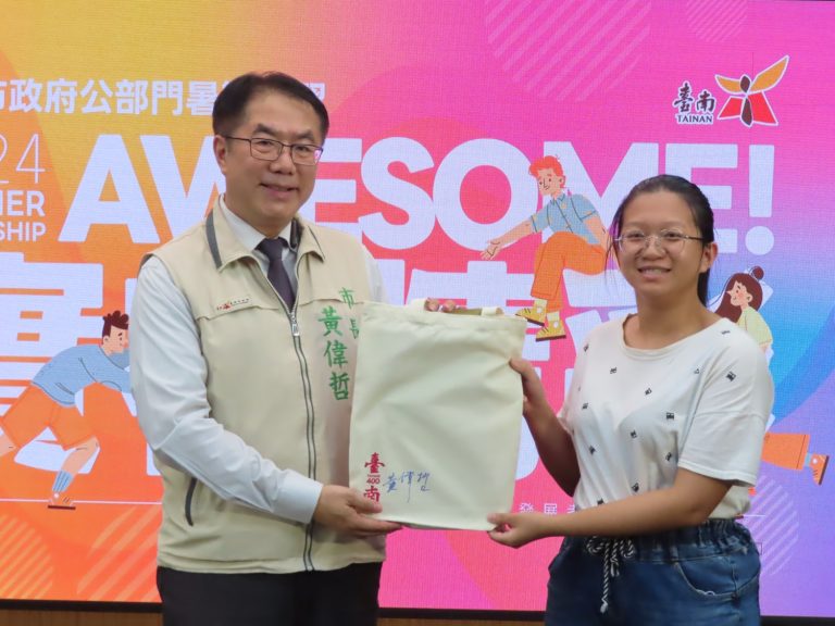 黃偉哲市長(左)特別準備台南400簽名紀念提袋，送給首位報名實習生青年設計系的金門大學李孟昀同學。(圖／台南市政府)