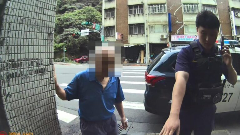 警方查詢老翁詢身分並引導至屋簷下避雨 。(圖/記者薛秀蓮 翻攝)