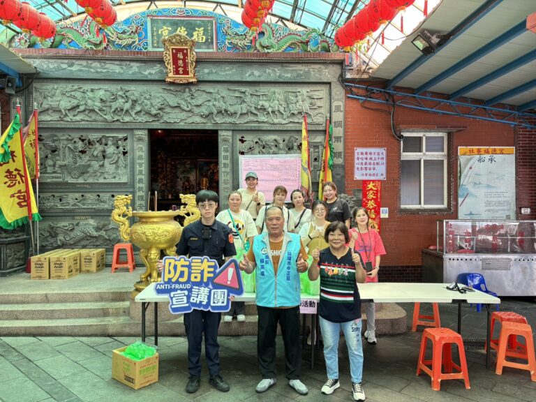 警方手持防詐標語與民眾大合照。(圖/記者薛秀蓮 翻攝)