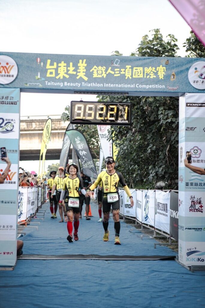 陳彥良（右）與洪緯欣（左）完成113公里賽程攜手通過「台東之美鐵人三項國際賽」終點線，象徵愛與鐵人精神的雙重勝利。（圖/記者張家燁翻攝）