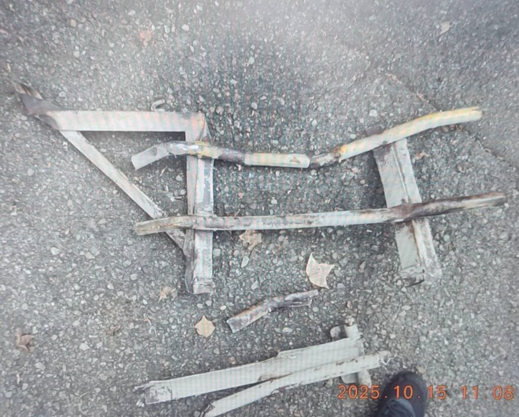 掉落在道路上的防捲入裝置欄杆,因鬆脫飛出導致自小客車受損。(圖/記者林家嘉翻攝)